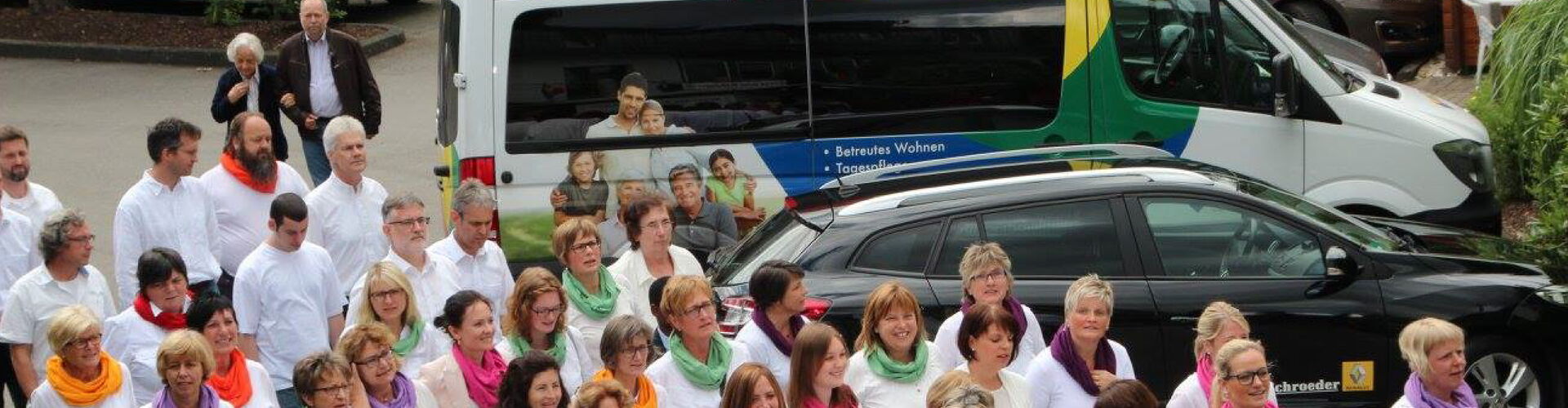 Das große Team der Reinery Pflege vor einem der Firmenbusse; Zusammenhalt und Vielfalt in der Mitarbeiterschaft.